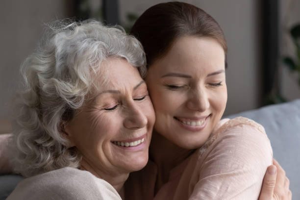 istock Close up head shot devoted old mother cuddling grownup daughter. 1404531556