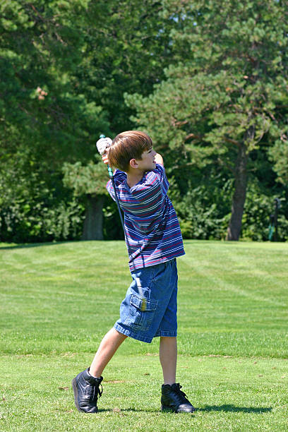 istock Boy swinging golf club 140453442