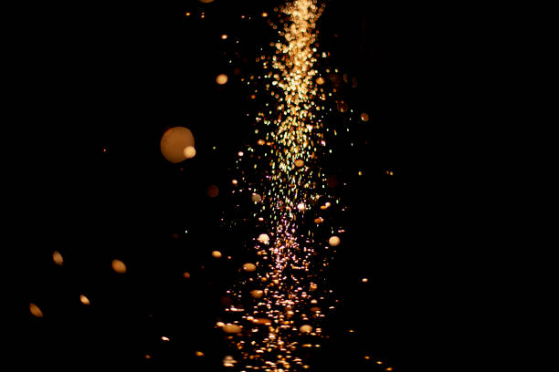 istock Sparks in dark. Flow of sparks from metal processing. Lights on black background. Work in workshop. Grinding steel. Many small particles burn brightly. 1404534599