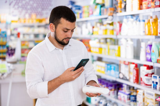 istock Male customer scans barcode on a medicine box using her smartphone 1404538107