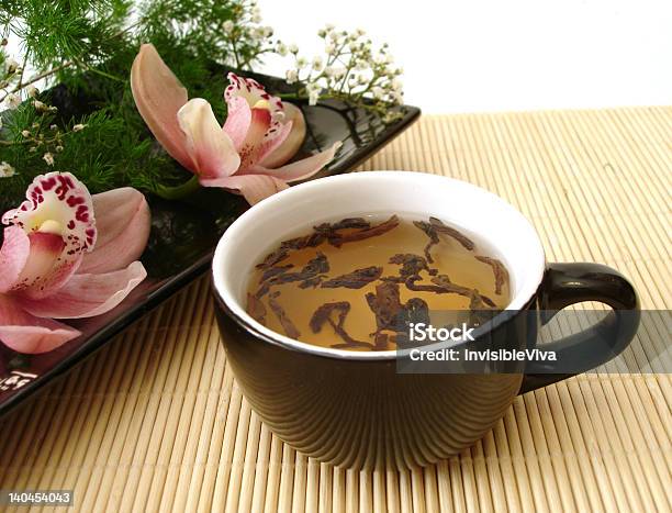 Foto de Xícara De Chá Com Orquídeas Em Um Prato Com Palha Matt e mais fotos de stock de Alimentação Saudável