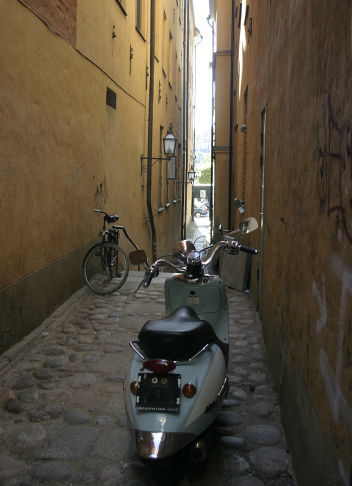 The couple of two-wheelers at the narrow street. Old town in Stockholm.  