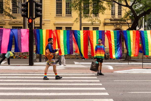 des drapeaux arc-en-ciel sont accrochés et des gens sur l’avenida paulista lors du défilé de la fierté lgbt à são paulo, au brésil. - homosexual gay pride business rainbow photos et images de collection