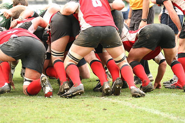 muddy male rugby players tackling each other - rugby scrum stockfoto's en -beelden