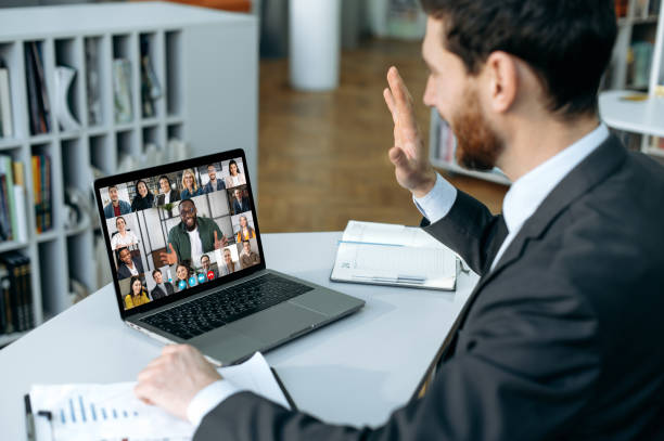 istock Successful man using a laptop, conducts virtual meeting with business partners on a video call. Group of diverse multiracial business people on laptop screen holding video conference 1404549111