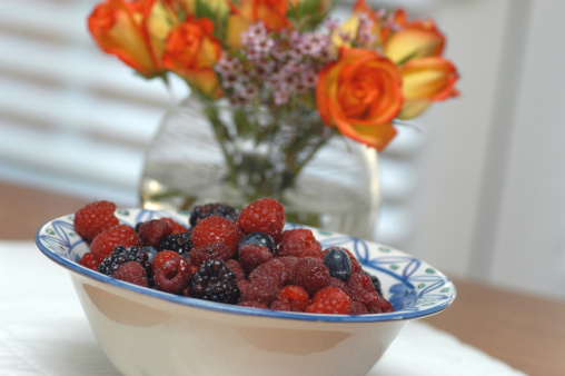 Fresh berries in a bowl with flowers