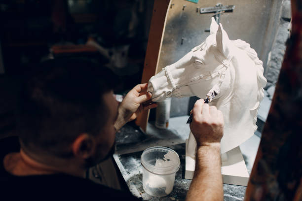 istock Artisan craftsman create mask based on plaster cast. Gypsum mold and plastic mask sculpting 1404553331