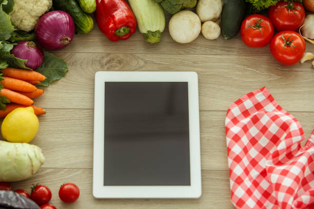 istock Digital tablet is an useful tool in preparing recipes with fresh vegetables 1404553549