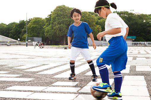 Osango, Indonesia - August 17, 2014: Group of unidentified funny children of indonesian ethnicity playing football with adult european man in the village of Osango, Mamasa region, Sulawesi, Indonesia.