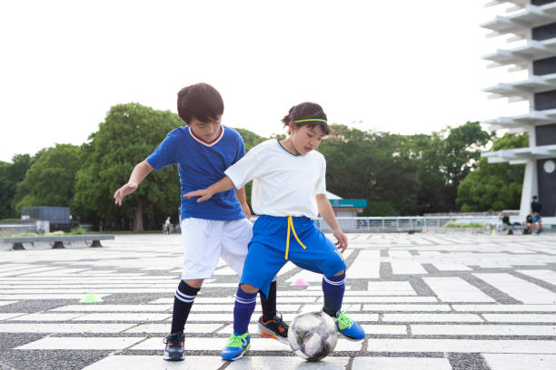 istock Elementary school boys and girls playing soccer. 1404559803