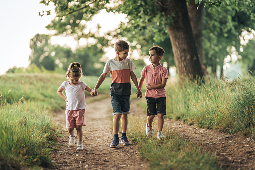 Happy kids play outdoor. Children skipping rope in sunny garden. Summer holiday fun. Group of school children playing in park playground. Healthy outdoors activity. Sport for child.