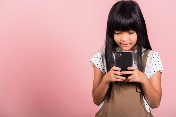 istock Asian kid 10 years enjoying using mobile phone for social network media 1404567325