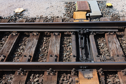 Close-up of a railroad switch with electric actuator for remote control of direction change of trains on railway tracks