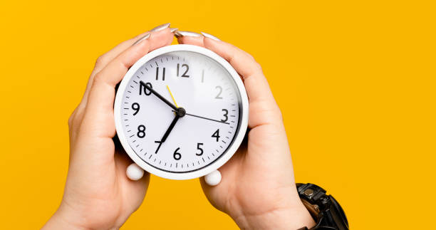 istock white alarm clock on hand the importance of time time and work time concept 1404573284
