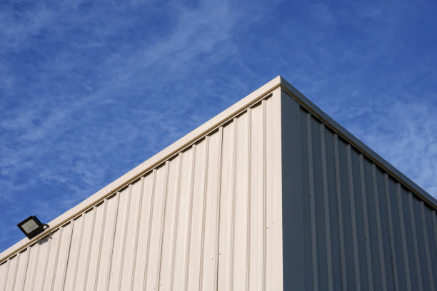 istock Sunlight on surface of white corrugated steel warehouse wall against clouds on blue sky background 1404573503