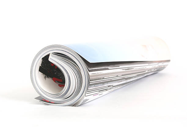 magazine roll shot of the magazine roll (Shallow DOF) on a white background with pretty shadow rolled up magazine stock pictures, royalty-free photos & images