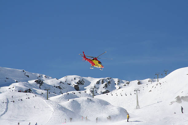Mountain rescue helicopter flying over the snow to aid