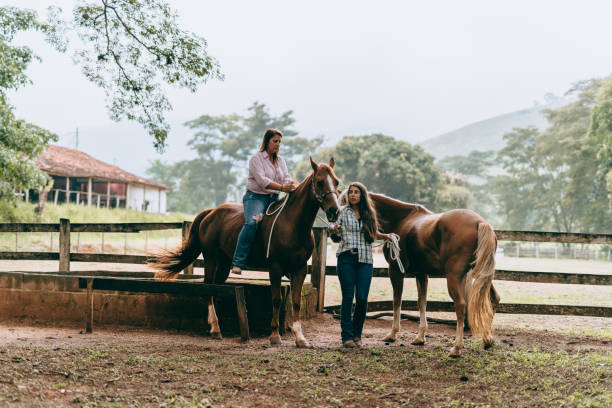 istock Mother and daughter preparing to mount on the ranch 1404581298
