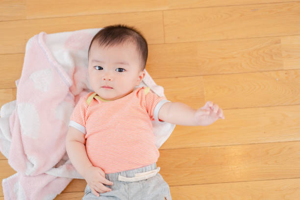 bébé allongé sur le sol de votre maison - baby yawning asian ethnicity newborn photos et images de collection