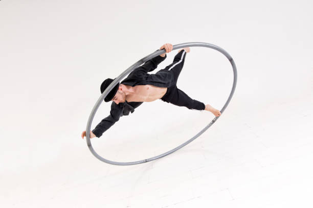 istock Acrobat performing a coin trick on a cyr wheel 1404582675
