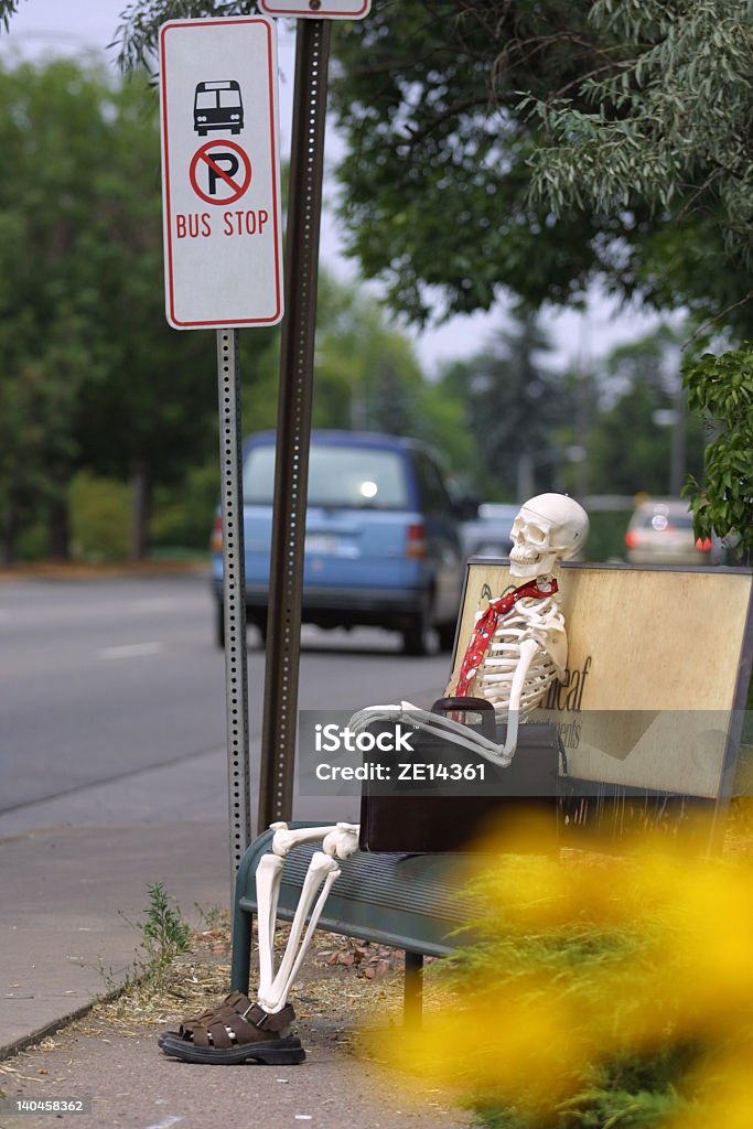 Waiting FOREVER for a bus A skeleton representing a business person who has died waiting for a bus at the bus stop. Human Skeleton Stock Photo