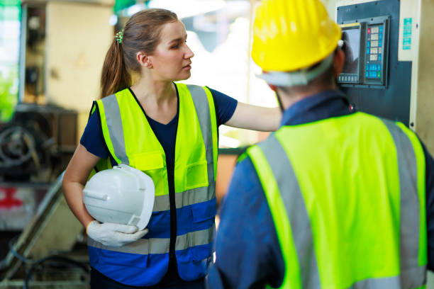 istock caucasian female engineering worker wearing safety hardhat helmet inspecting auto robot lathe machine to drill components. Metal lathe industrial manufacturing factory 1404591389