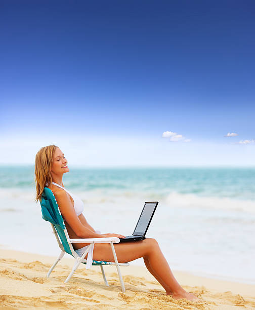 istock Beautiful young woman on the beach with laptop 140459233