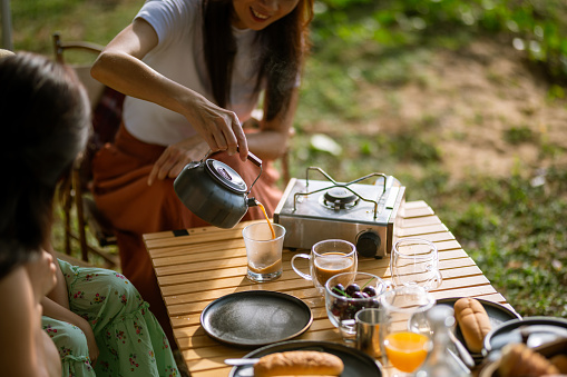 Happy Asian family enjoy coffee and juice during picnic  - Camper van travel series