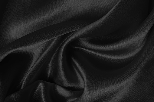 Black fabric cloth texture for background and design art work, beautiful crumpled pattern of silk or linen.