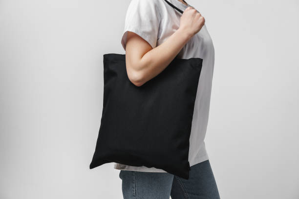 female holding black cotton bag in her hands on white background - 環保袋 個照片及圖片檔