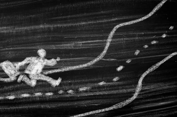 Yellow painted CRIMINAL text on black asphalt with road line, crime scene tape style street marking