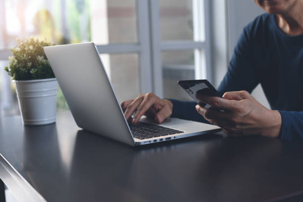 istock Casual business man working on laptop and using mobile phone at home office 1404602601