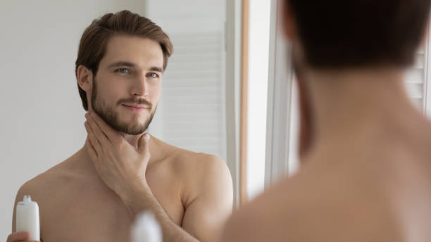 istock Pleasant young handsome caucasian man applying moisturizing lotion. 1404603913