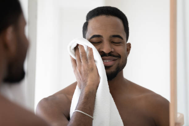 istock Happy young mixed race african man wiping face with towel. 1404603920