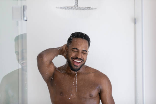 istock Happy young african american biracial bare man taking shower. 1404603927