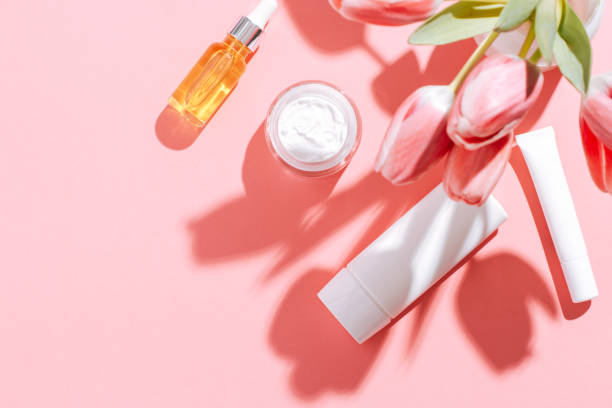 istock Spring cosmetic flat lay frame with flowers on pink, copy space, top view. 1404605859