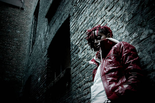 Young Woman in Dark Alley Lonely black woman in a dark alley. gangster rap stock pictures, royalty-free photos & images