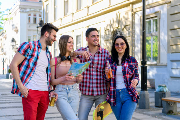 Group of tourists searching for places on their map outdoors.