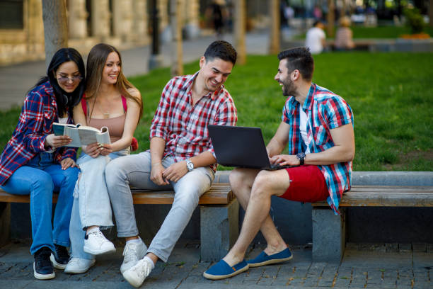 istock Happy young teens group sitting on bench and having fun 1404608368