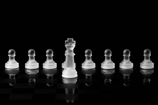 King leading pawns em fundo preto - foto de acervo