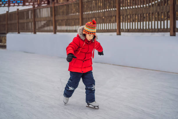 un garçon qui vient d’apprendre à patiner sur glace - ice hockey action ice skating ice skate photos et images de collection