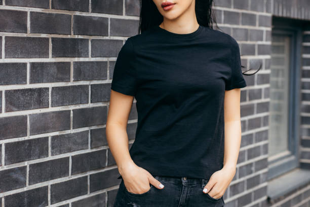 стильная брюнетка азиатская девушка в черной футболке и солнцезащитных очках позирует на фоне уличной, городской одежды стиля. уличная фот - letter t фотографии стоковые фото и изображения