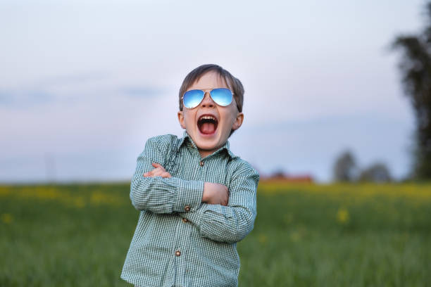 istock boy playing in a green meadow with yellow flowers 1404612381