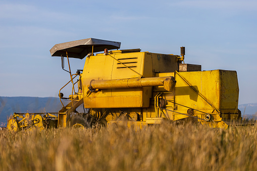 Large yellow combine harvester in the field