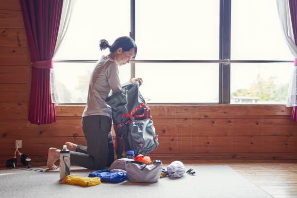 ロッジで荷物をまとめ、明日のトレッキングの準備をするアジア人女性 - osaka prefecture japanese culture japanese ethnicity japan ストックフォトと画像