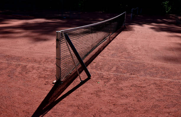 분쇄 된 벽돌의 붉은 표면이있는 테니스 코트. 경기장의 점토는 정기적 인 유지 보수가 필요합니다. 롤링 및 스윕, 먼지가 많은 표면은 게임 전에 물을 뿌려야합니다. - superior court 뉴스 사진 이미지