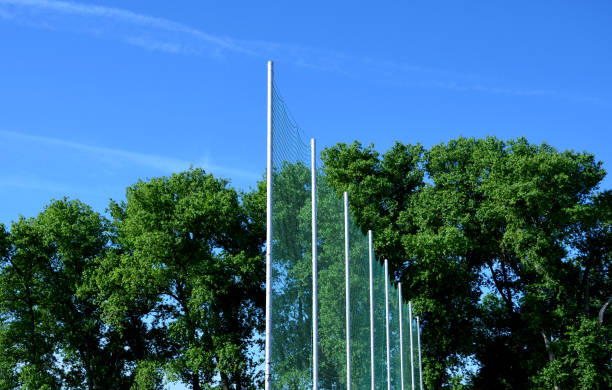 filets de sécurité élevés faits de poteaux et de filets métalliques sur le terrain de rugby, stade d’athlétisme de football. les spectateurs s’assoient à proximité et sont protégés des balles et des objets volants - vacant block photos et images de collection