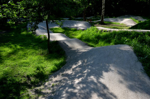 istock forest in which there is a track for bicycles trail tilted bends one after the other dug in the ground into perfect shapes mountain bikes even for children, glade, sun, shadows, racing  new, lawn 1404614978