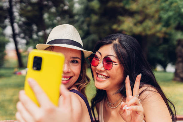 istock Diverse girlfriends taking selfie in park 1404616459