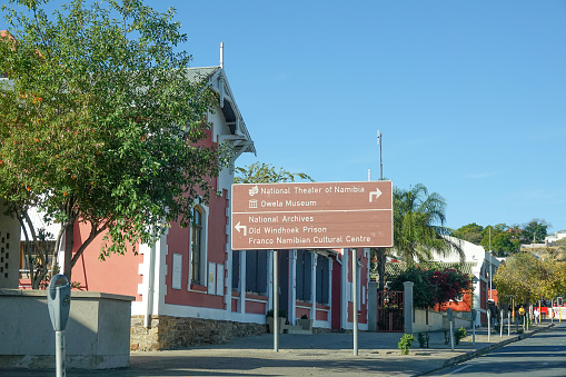 Road Sign to National Theater of Namibia in Windhoek at Khomas Region, Namibia, with people in the background.
